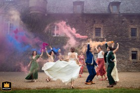 At the historic Château de Labro in Onet-le-Château, the scene captures a moment of fluidity and vibrant colors, likely showing the bride's dress or decor against the rustic castle backdrop.